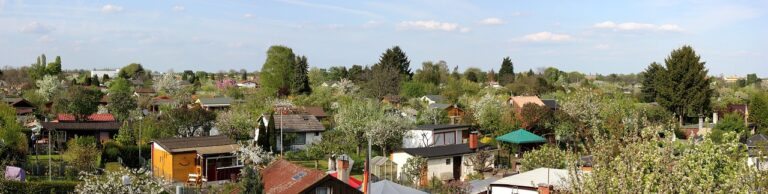 Kompakter Mähroboter mäht selbstständig kleinen Kleingarten mit unregelmäßigen Flächen