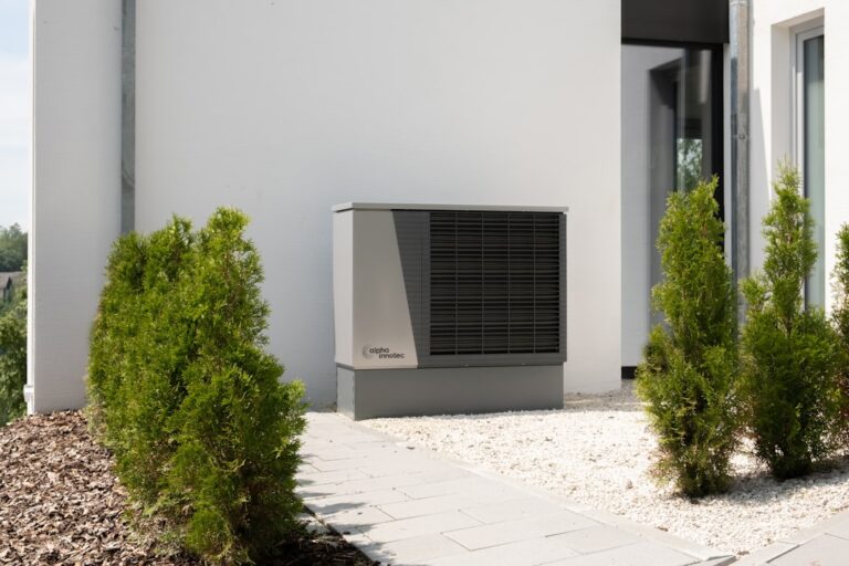 Wie Wärmepumpe und Mähroboter im Garten harmonisch zusammenarbeiten Wärmepumpe im Garten neben Mähroboter für harmonisches Zusammenspiel